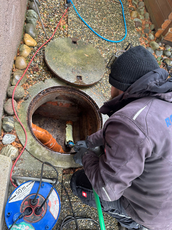 Rohrsanierung am offenen Kanalschacht durch Rohr-Fix Techniker